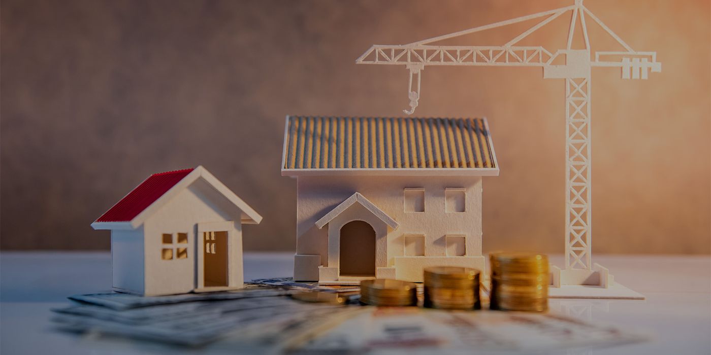 Maqueta de casas con grúa y monedas, de la idea a la obra